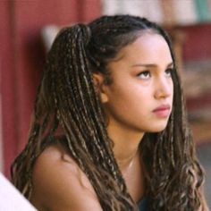 a woman with long dreadlocks sitting down