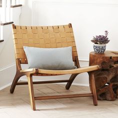 a wooden chair sitting next to a tree stump with a plant on top of it