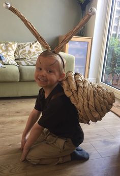 a young boy is sitting on the floor with a basket in front of his face