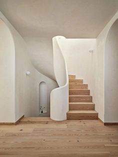 a white staircase leading up to a room with wooden floors