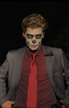 a man in a suit and tie with his face painted like a clown