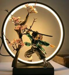 a figurine is posed in front of a circular light with flowers on it