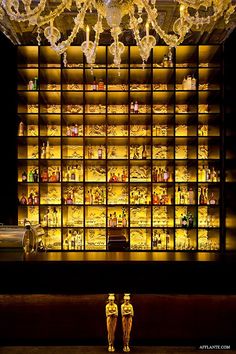 two gold figurines in front of a lighted display case