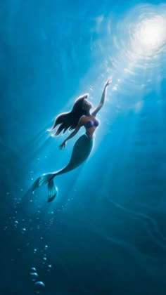 the little mermaid is swimming under water