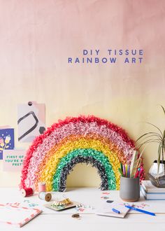 a rainbow made out of yarn sitting on top of a table next to other items