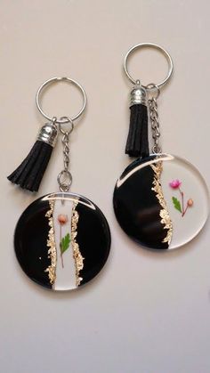 two black and white key chains with flowers on them