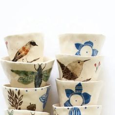 a stack of ceramic bowls with birds painted on them