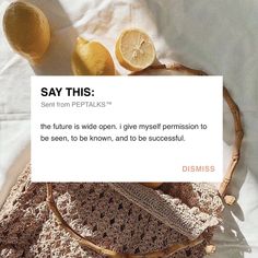 a basket filled with lemons sitting on top of a white bed next to a piece of paper