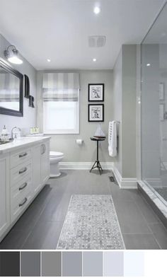 a white bathroom with gray tile flooring and walls