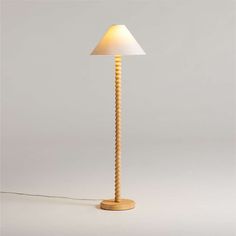 a wooden lamp with a white shade on it's head and cord attached to the base