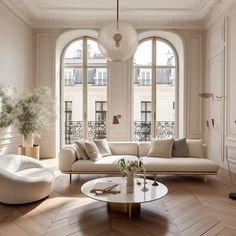 a living room filled with white furniture and large windowed windows next to a wooden floor