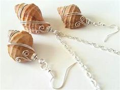 three seashells are attached to silver chains