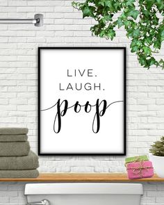 a bathroom with a white brick wall and a black framed poster that says live laugh pop