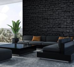 a modern living room with black brick wall and large window overlooking palm trees in the distance