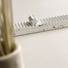 a ruler sitting on top of a table next to a plant