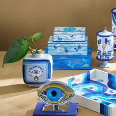 an assortment of blue and white vases on display with a plant in the middle