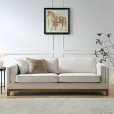 a living room with a couch, table and vase on the floor next to it