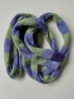 a purple and green scarf on a white surface