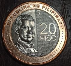 a close up of a metal coin with a man's face on the front