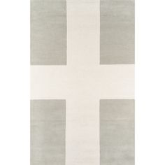 a white rug with grey squares and a cross on the front in an otherwise neutral color scheme