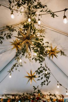 the ceiling is decorated with gold stars and greenery hanging from it's sides