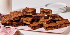 a white plate topped with brownies next to a glass of milk