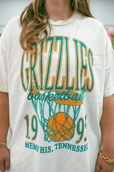 - Features Grizzlies with a basketball and hoop underneath and the established year with Memphis, Tennessee underneath all in orange and turquoise ink - Oversized fit - Sizing translation: XS/S : L , S/M : XL Vintage Sports T Shirt, Cute School Tshirt Designs, Vintage Basketball Shirt, High School Basketball Shirts, Oversized Tshirt Design, Football Giveaways, Puff Print Tshirt, Basketball Warm Up Shirts, Vintage College Shirts