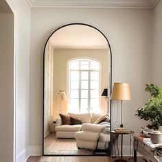 a living room with a large mirror on the wall next to a couch and table