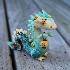 a blue and white dragon figurine sitting on top of a wooden table next to flowers