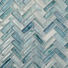 blue and white glass mosaic tile in the shape of herringbones on a wall