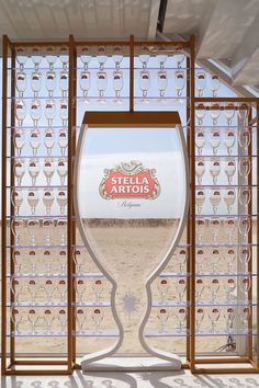 a large wine glass sitting on top of a counter next to a wall filled with glasses