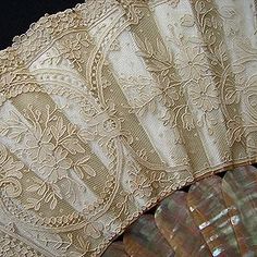 an old lace fan sitting on top of a table