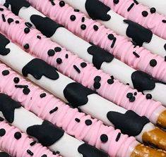 many decorated cookies are lined up together on the table, with black and white icing