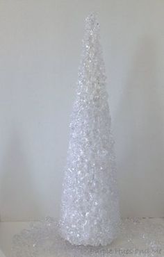 a white plastic christmas tree sitting on top of a table