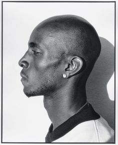 a black and white photo of a man with ear piercings