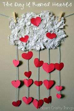 the day it rained hearts are hanging from clothes pins on a string with paper hearts attached to them