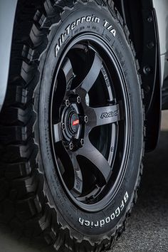 the front wheel and tire of a truck with black spokes, tires and rims