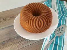 a bundt cake sitting on top of a white plate next to a knife and fork