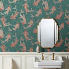 a bathroom sink sitting under a mirror next to a wall mounted faucet in front of a green wall