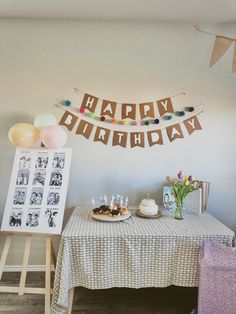 a birthday party with cake and balloons on the table in front of a sign that says happy birthday