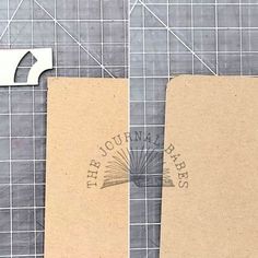 two pieces of cardboard sitting next to each other on a table with scissors and tape