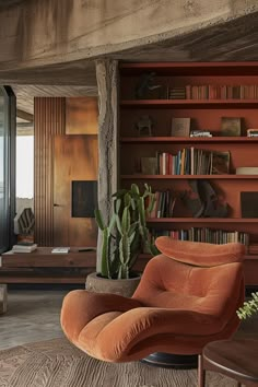 a living room with an orange chair and bookshelf in the corner, next to a potted cacti