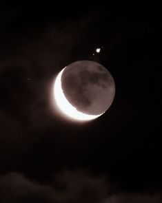 the moon is almost obscured by clouds as it passes in front of an object that appears to be half - moon