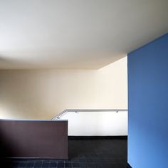 an empty room with blue walls and tiled floor