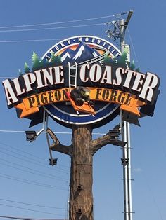 a large sign for alpine coaster on top of a wooden pole