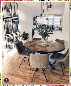 a dining room table with chairs and pictures on the wall