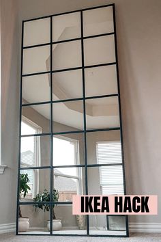 a large mirror sitting on top of a white floor next to a potted plant