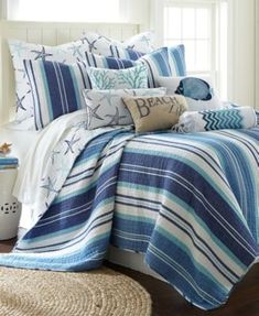 a bed with blue and yellow striped comforter on it's side, next to a night stand