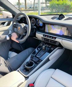 a man sitting in the driver's seat of a car with his hands on the steering wheel