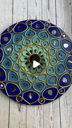 a blue and gold clock sitting on top of a wooden floor